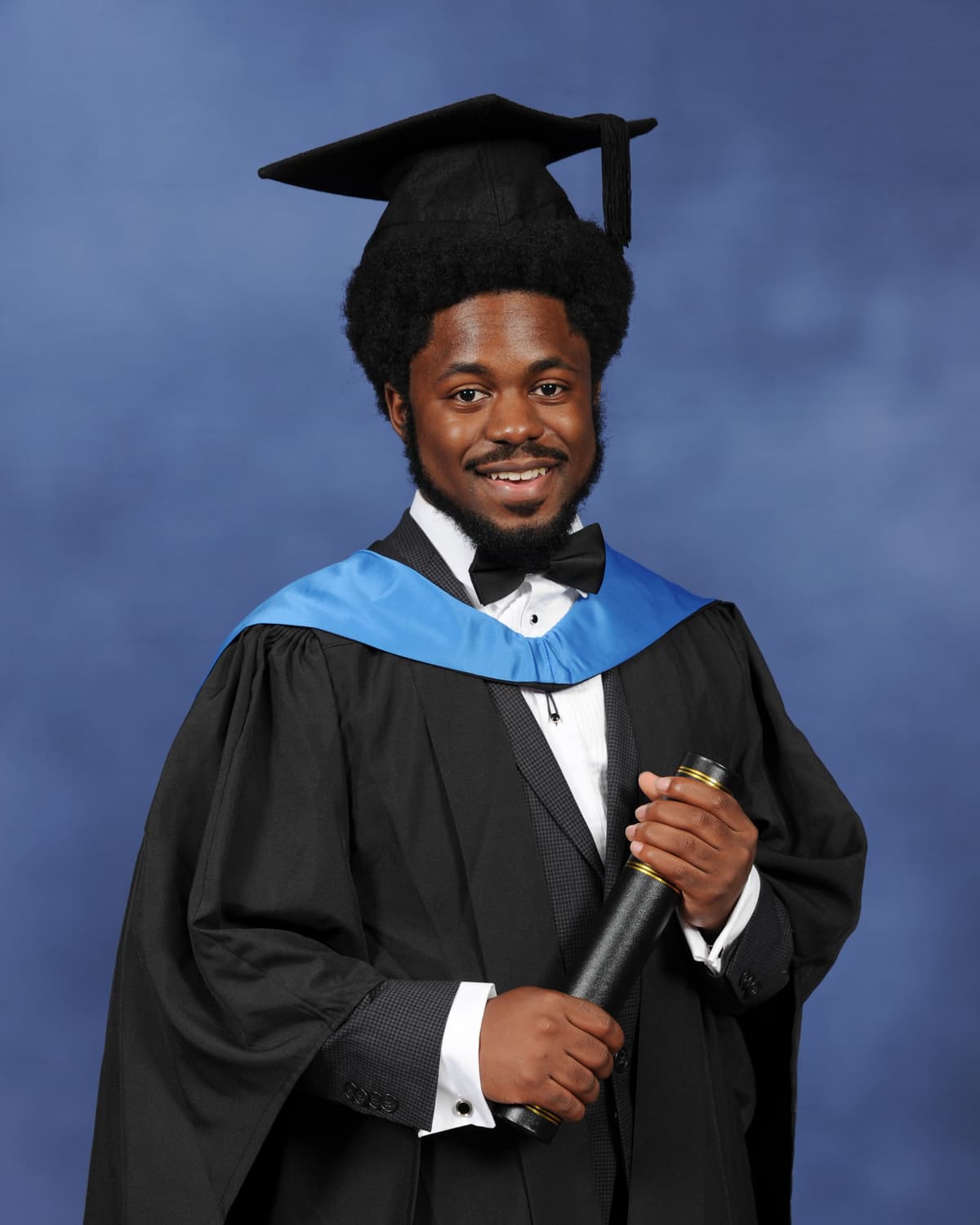 Portrait of Enric Trillo, standing confidently with graduation attire, exuding a approachable and joyful aura.
